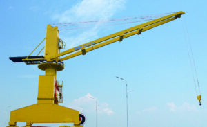 Grue portuaire jaune en service, bras télescopique déployé, levage maritime industriel au Maroc